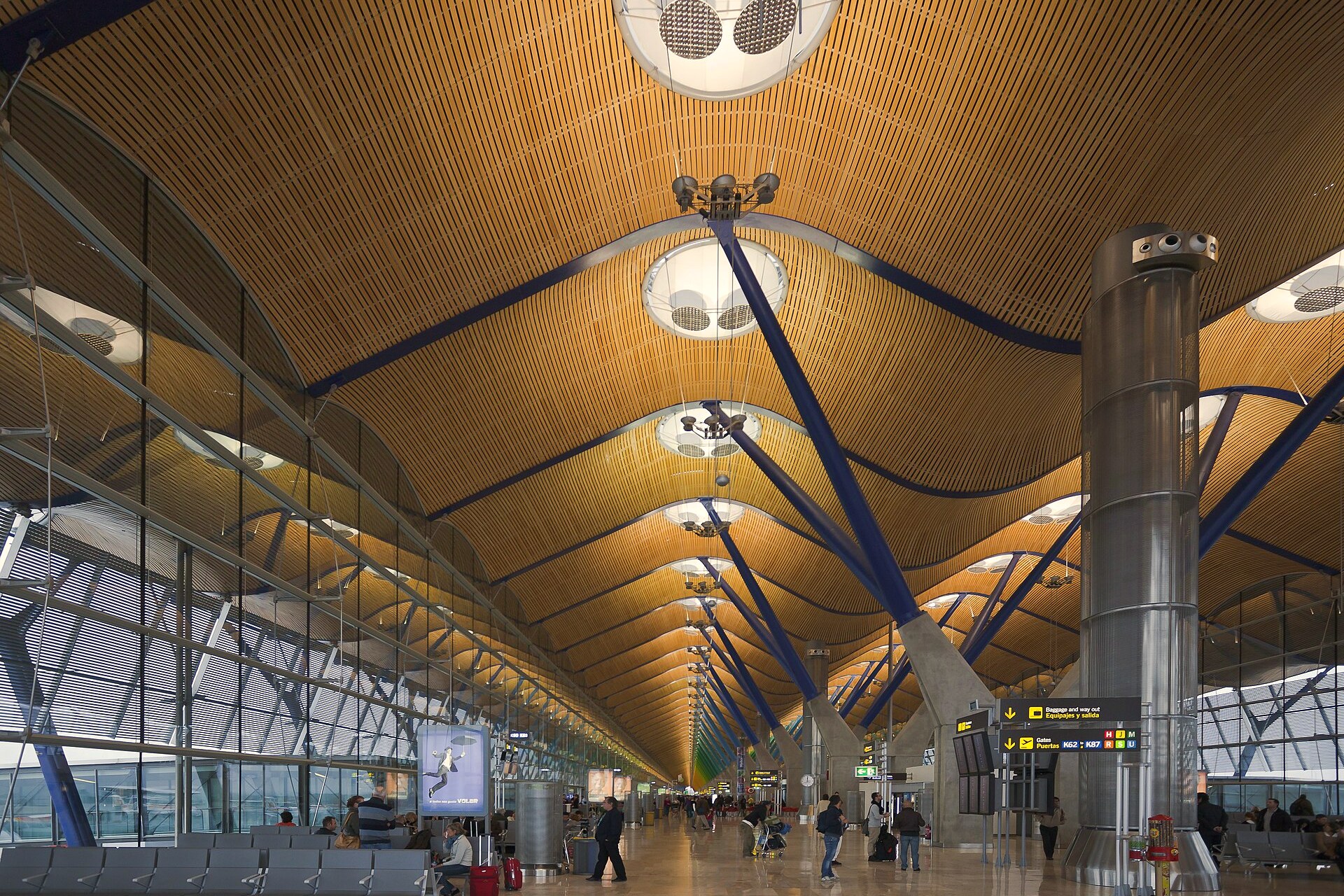 Saguão do Terminal 4 de Madri, com teto ondulado de bambu e passageiros caminhando ao fundo
